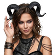 Woman wearing black ram horns and a black outfit with chain details on a white background
