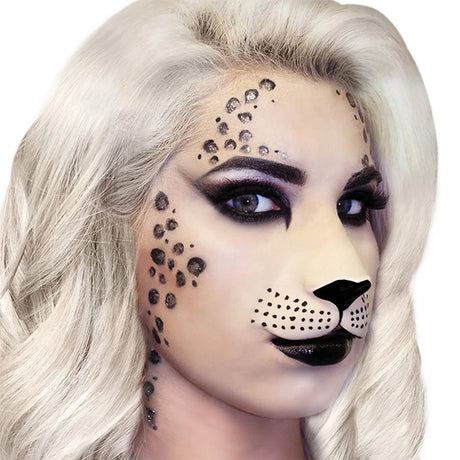 A close-up of a model with platinum blonde hair wearing animal print makeup, featuring black leopard spots on the forehead, cheek, and jawline, and a black nose on a pale base.