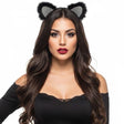 A woman with long wavy brown hair wearing a pair of black cat ears headband with glittery silver tips, paired with a black off-the-shoulder top, against a solid white background.